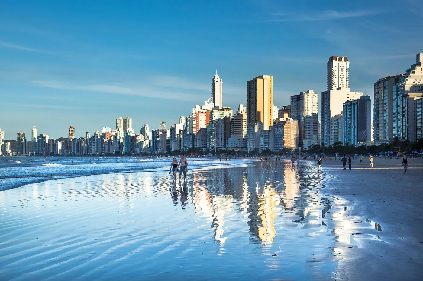 Praia Central de Balneário Camboriú com os prédios refletidos na areia molhada